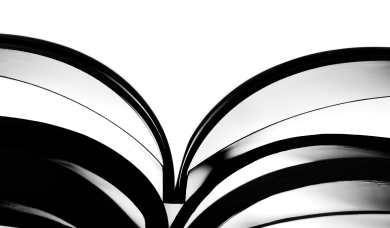 High-contrast black and white photograph of an open book, its pages fanned symmetrically